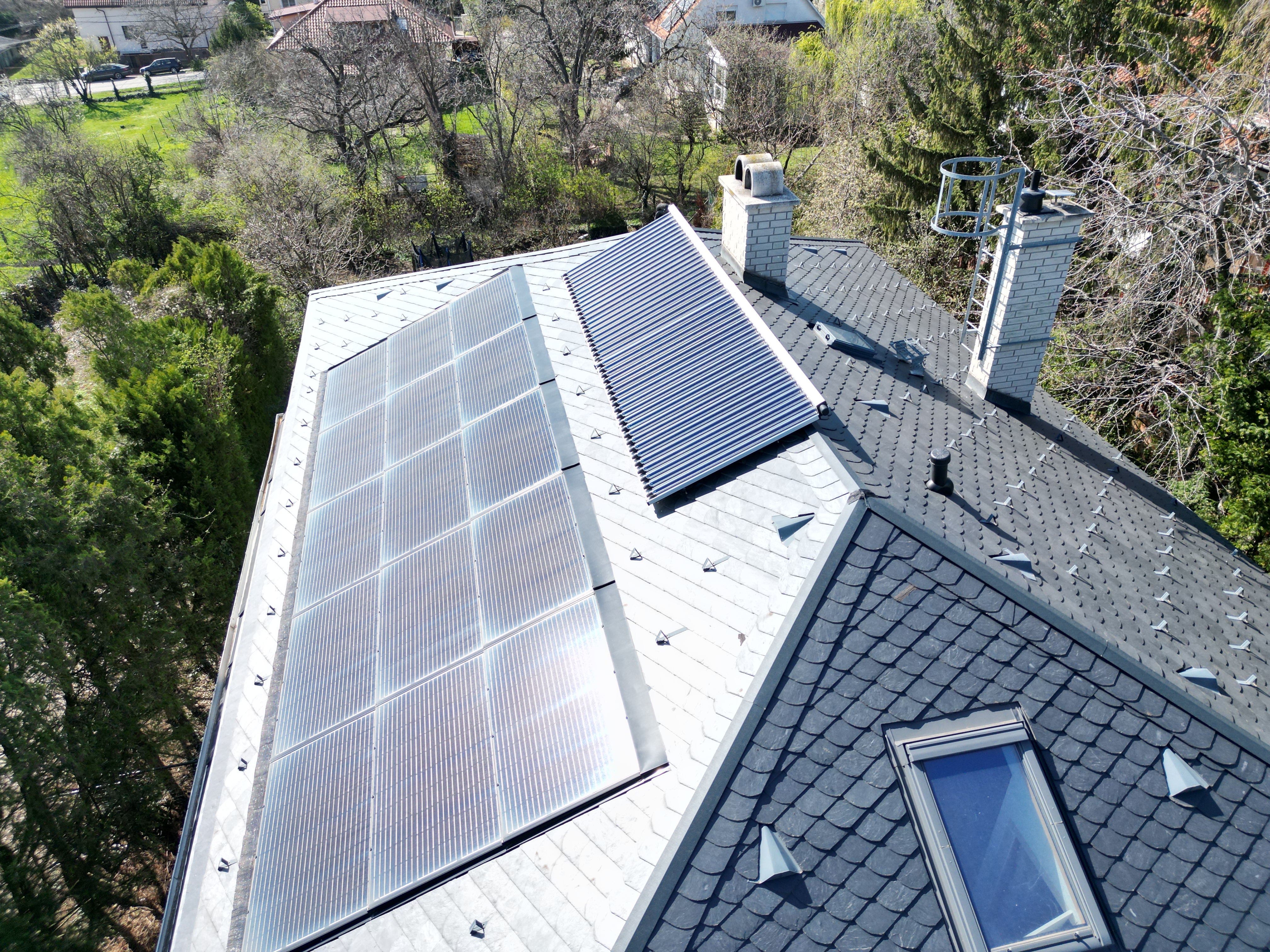 Hybrid rendszer: vizes napkollektor, tetőbe integrált napelemes rendszer, kondenzációs gázkazán, frissvízmodul, 600 l rétegtöltésű puffertároló, szintenkénti fűtésvezérlés