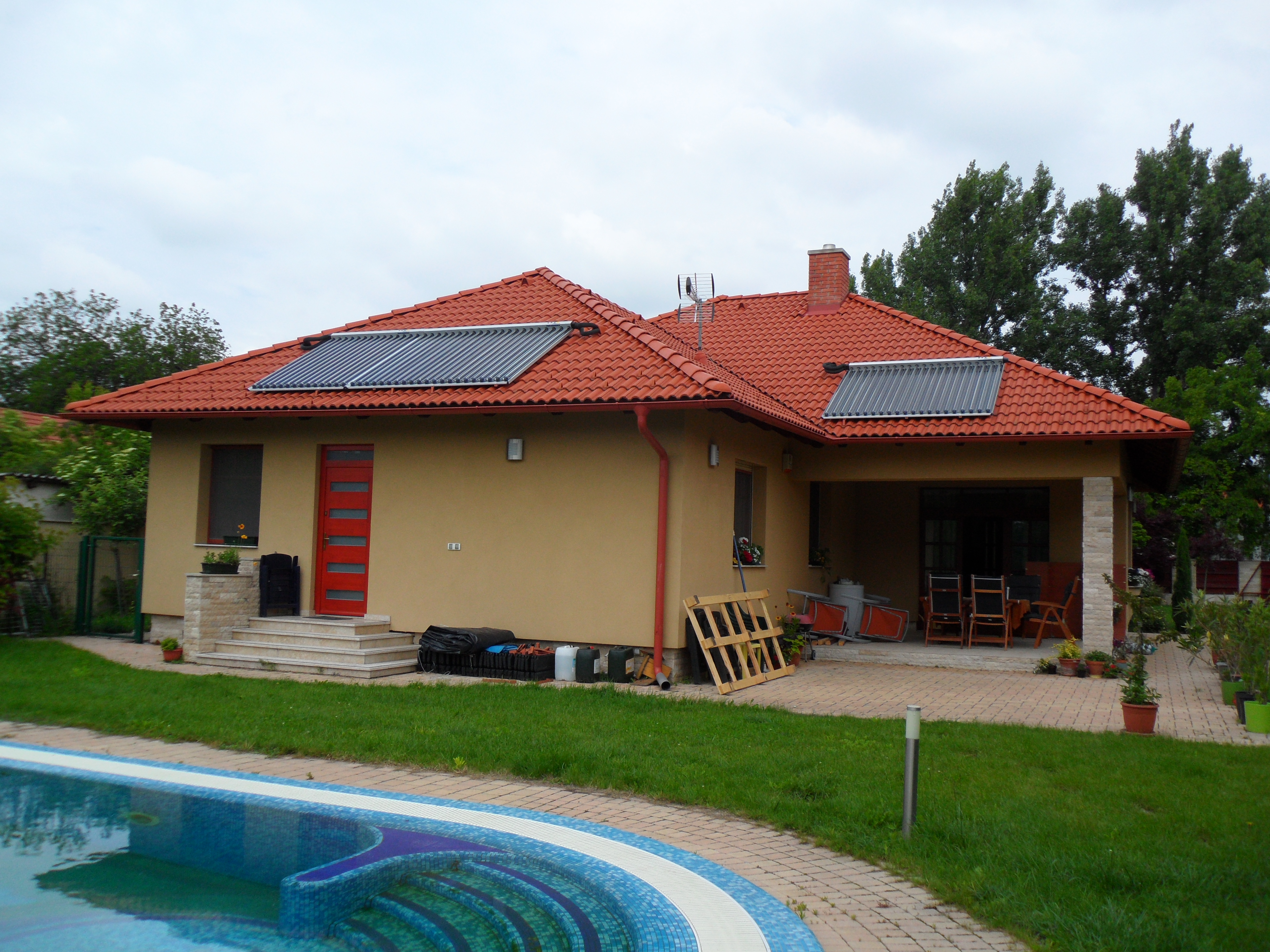 Hybrid rendszer családi házban: vizes napkollektoros rendszer, napelemes rendszer, 1000 l rétegtöltésű puffertartály frissvízmodullal, kondenzációs gázkazán, vízteres kandalló, mikroprocesszoros fűtés- és medencevezérlés