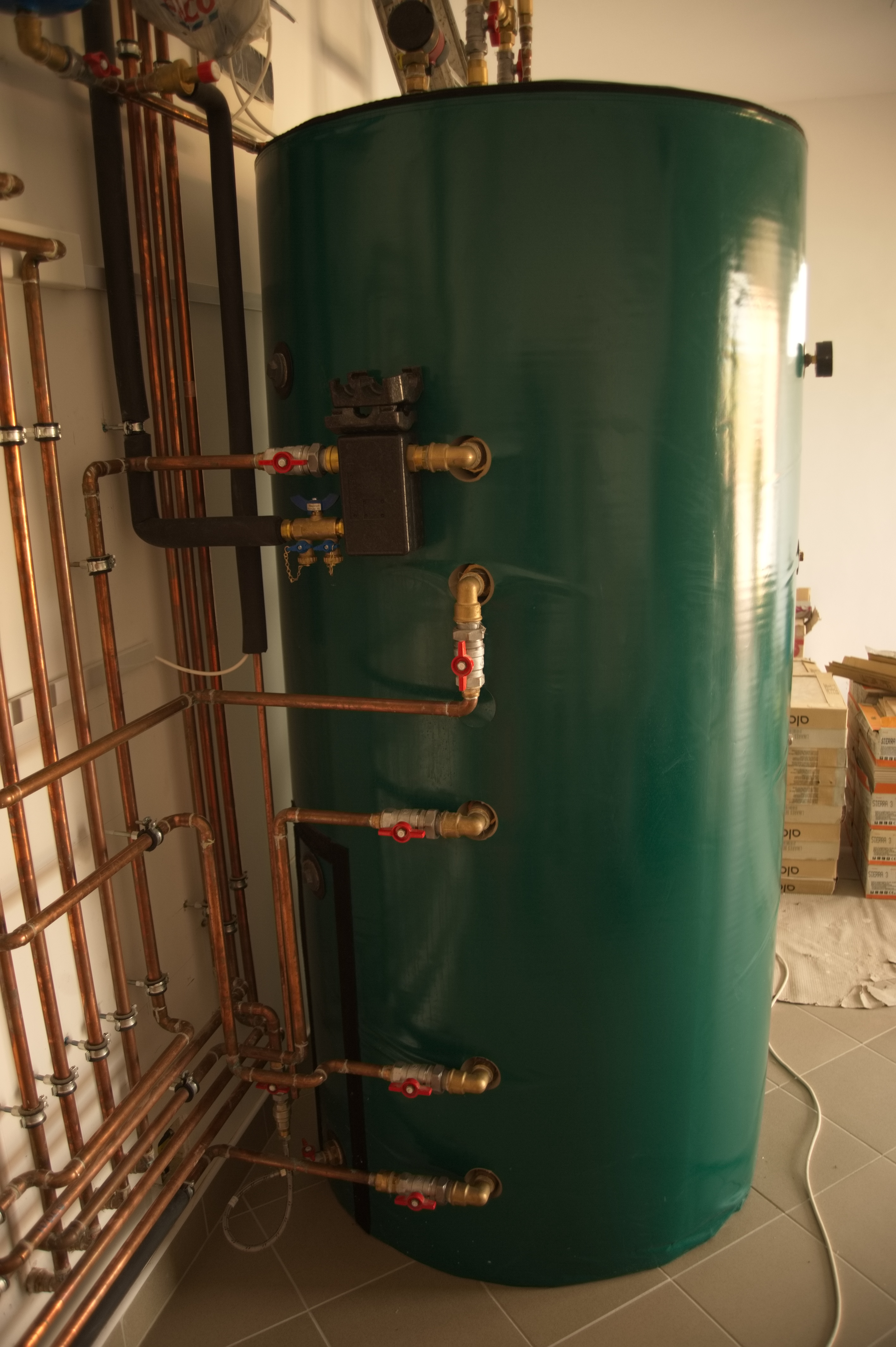 Hybrid gépészet családi házban: vizes napkollektoros rendszer, 1000 l rétegtöltésű puffertartály, indirekt HMV tartály, kondenzációs gázkazán, vízteres kandalló, mikroprocesszoros fűtésvezérlés