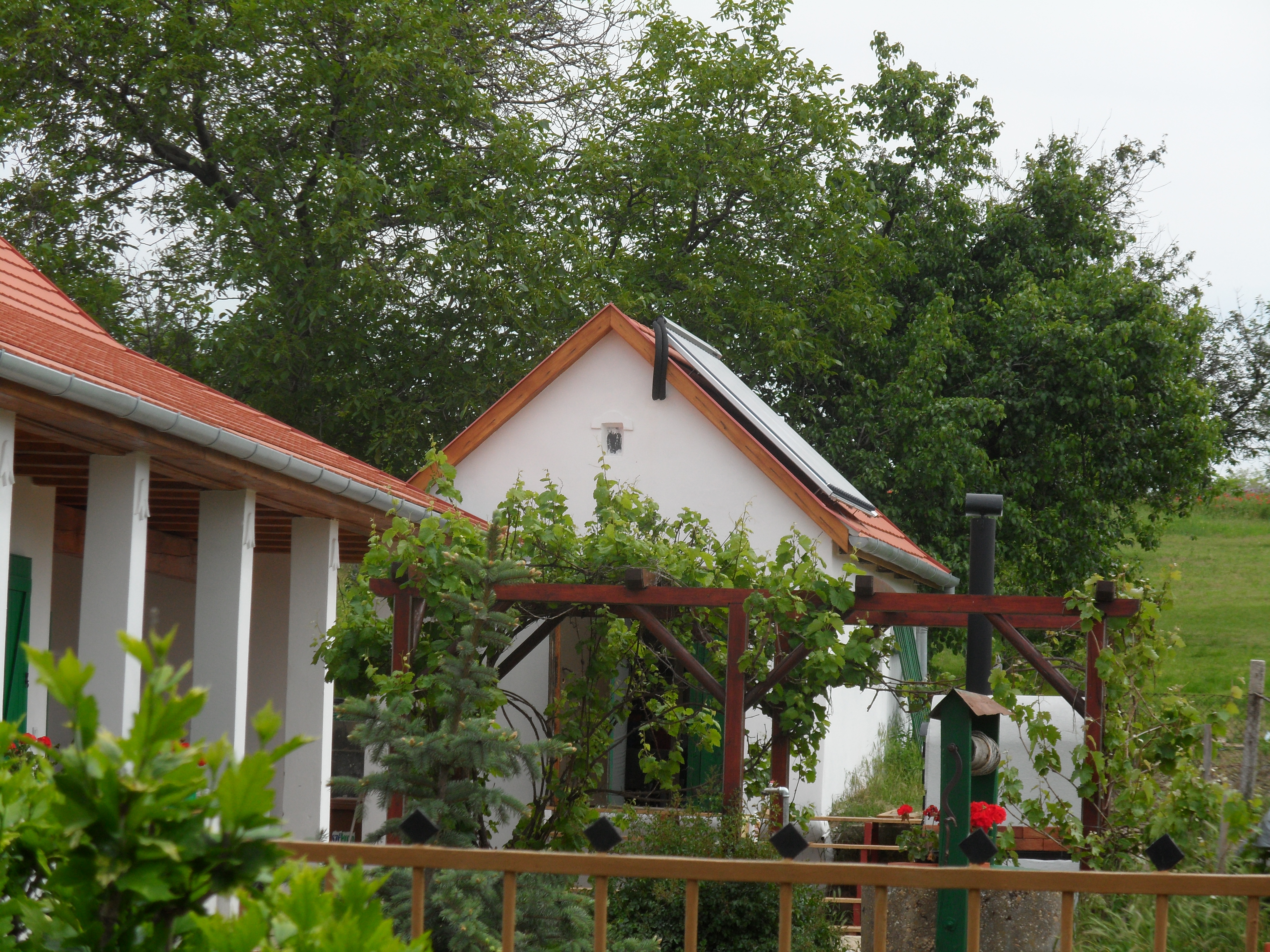 Hybrid gépészeti rendszer vizes napkollektoros rendszerrel, 2 x 500 l rétegtöltésű puffertartály kaszkád-kötésben, frissvízmodul, kondenzációs kazán, fűtési rendszerbe integrált cserépkályha használata, mikroprocesszoros fűtésvezérlés